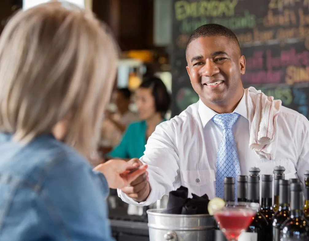 Customers at a bar paying their tab